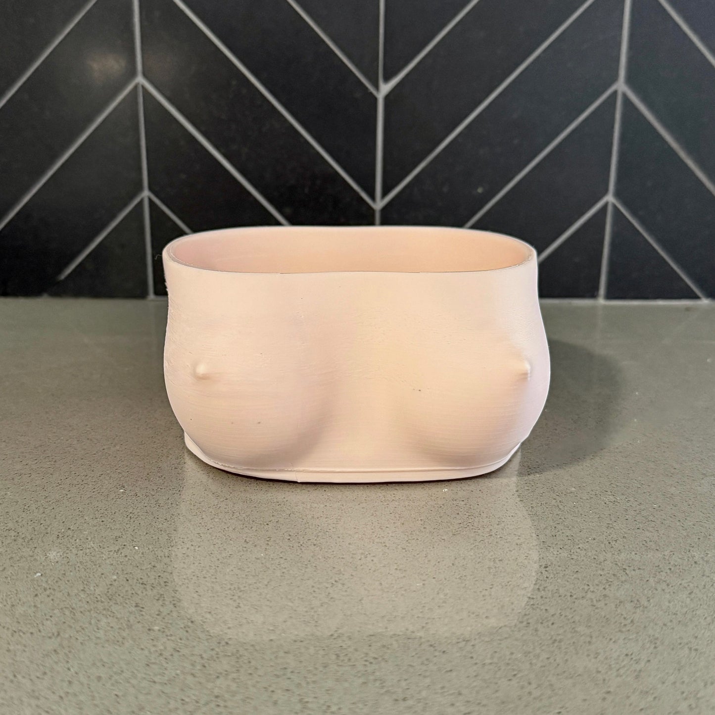 Topless female torso bowl by Peckers Co, side angle view on a kitchen counter